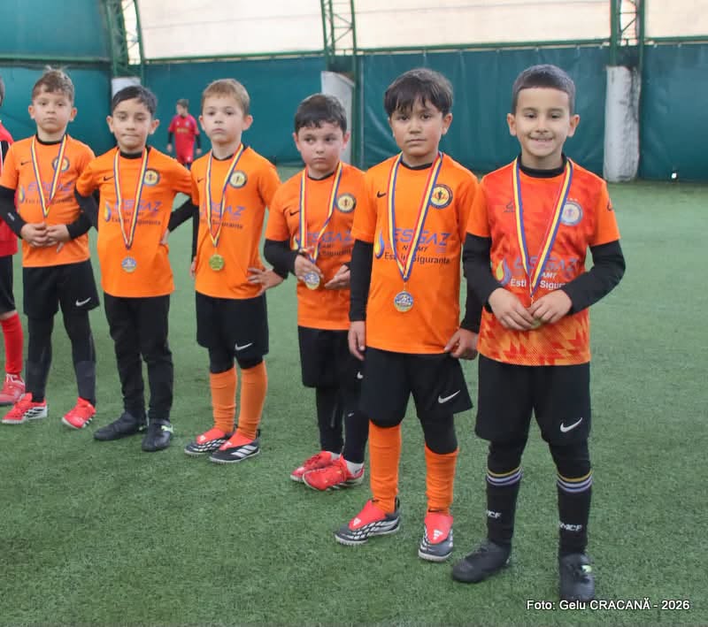 Copiii grupei 2018 de la Academia Dire & Alistar, în echipament portocaliu și negru, cu medaliile turneului